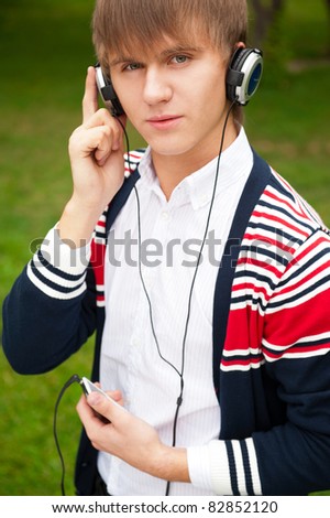 Student listening language course in headphones outside school