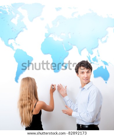 Geography lesson. Adult teacher giving presentation on white board with help of his student