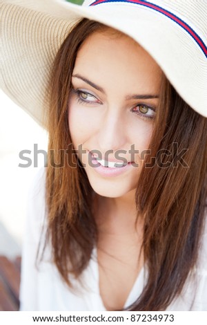 Beautiful young elegant woman wearing hat outdoor at park she is relaxed and daydreaming