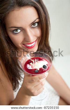 Portrait of an young beautiful woman eating an ice cream in cafe and looking at camera. Beautiful lovely eyes