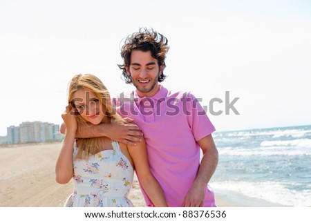 Couple at the beach holding hands and walking. Sunny day, bright colors. Europe, Spain, Costa Blanca