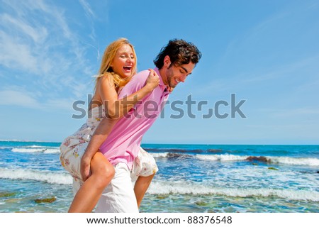 An attractive couple fooling around on the beach