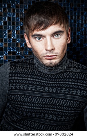 Fashion portrait of the young beautiful man inside luxury glamorous interior posing and looking at camera