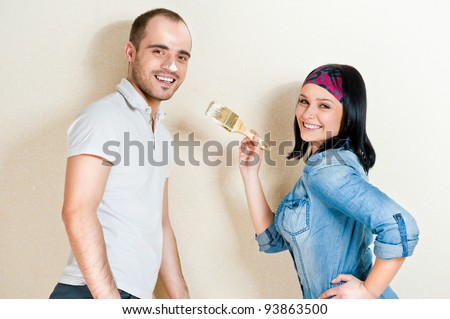 Happy young couple painting their house