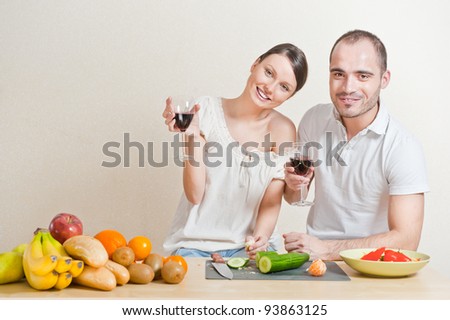 Young love couple cooking and drinking red whine from beautiful glasses. Big copyspace