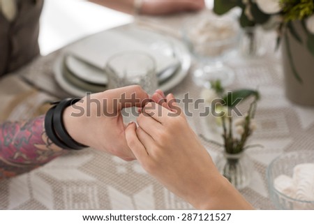 Bride and groom sitting together at the table before having dinner