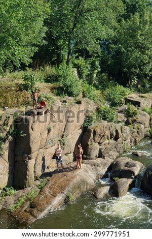 CORSUN-SHEVCHENKIVSKIY, UKRAINE - 24 JULY, 2015: young boys jump from a slope in the river of Ros\'. The river of Ros\' flows in the Tcherkasy area, Ukraine