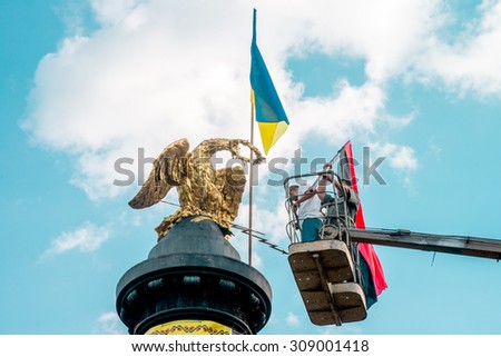 POLTAVA, UKRAINE - 23 AUGUST 2015: local residents and members of the volunteer battalions Celebrate Flag Day of Ukraine. Established flag on the tower.