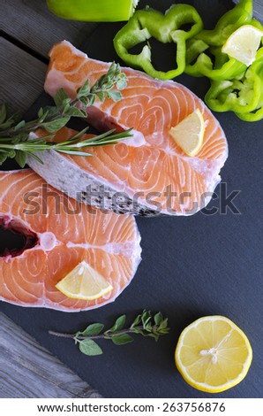 Fresh salmon steaks with aromatic herbs, spices, peppers  and lemon. Healthy food, diet or cooking concept.