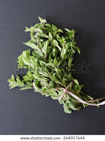 Fresh Kitchen Herbs for lamb oregano, mint, rosemary, lemon thyme on black stone as texture or background