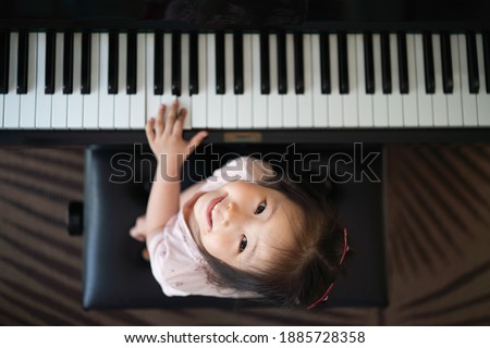 Similar – Image, Stock Photo Smiling child playing piano in cozy room in daylight