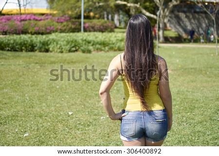Woman standing back watching the scenery in the park of Ibirapuera
