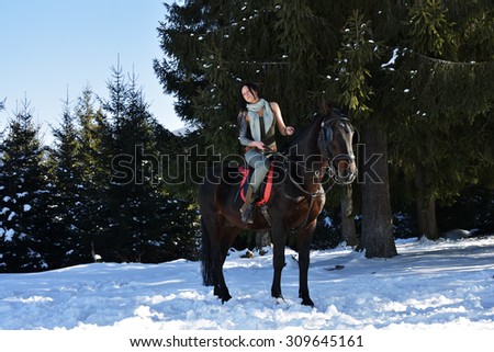 young woman riding horse outdoor in winter