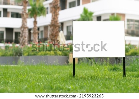 Empty template, advertising mock-up, banner on grass near pavement in city green park.Copy space for text.Information board on white background.  Foto d'archivio © 
