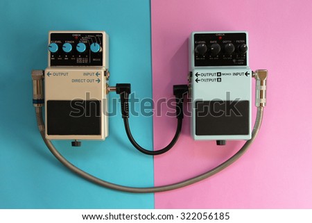 Guitar pedals on half blue half pink background - music concept