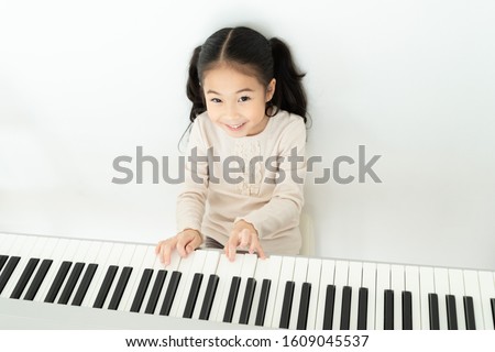 Similar – Image, Stock Photo Smiling child playing piano in cozy room in daylight