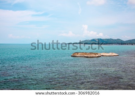 Idyllic blue sea and clear sky and stand-alone small island.