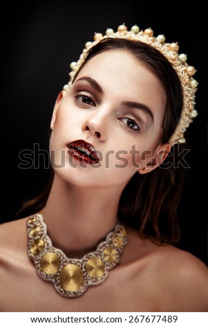 Pretty brunette female model face posing in studio with necklace