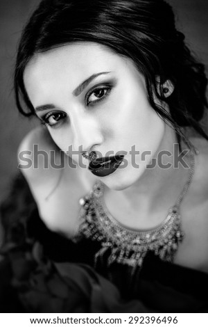 Beautiful woman with cute face bright make up red lips and piercing on nose black and white photo