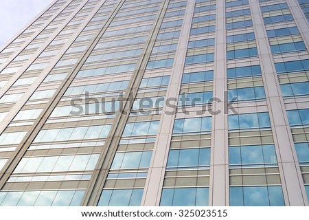 Perspective and underside angle view to textured background of mirror window glass building skyscrapers reflection with blue sky and white cloudy