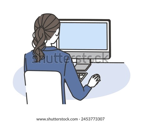 A woman in casual office wear working on a computer