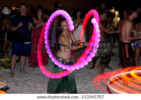 SIESTA KEY, FLORIDA - MAY 22: Dancers twirling colored perform in the center of a drum circle on Siesta Key Public Beach near Sarasota, Florida, May 22, 2011.