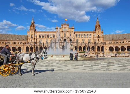 SEVILLE, SPAIN -Â� MARCH 26 2014: Tourists and a horse-drawn carriage by the fountain at the Plaza de Espana in Seville, Spain. The Plaza is a major tourist destination that was built in 1928.