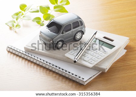 Toy car and calculator on the table.,to buy,sell,rent,repair or insurance