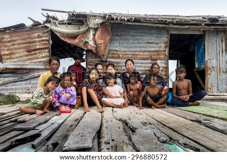 SEMPORNA, MALAYSIA - JUN 28 : Three generation of Bajau family sit outside their wooden stilt home Jun 28, 2015 in Sabah. The tribe are sea gypsies living in open sea with no school