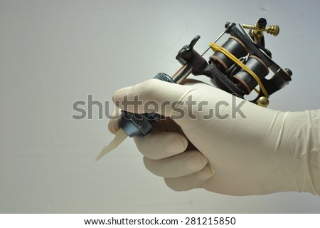 holding the tattoo gun