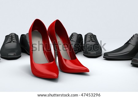 Men\'s black shoes placed around women\'s red shoes