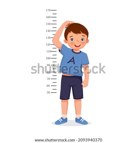 Cute Little boy measuring height of her growth on the background of wall