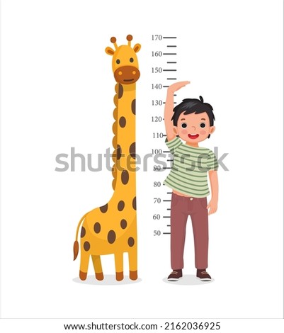 Cute Little boy measuring height of her growth on the background of wall with giraffe