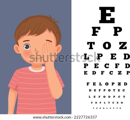 Cute little boy cover his eye having vision test reading block letters at ophthalmologist office