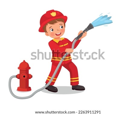 cute little boy wear firefighter uniform holding fire hose flowing water from fire hydrant