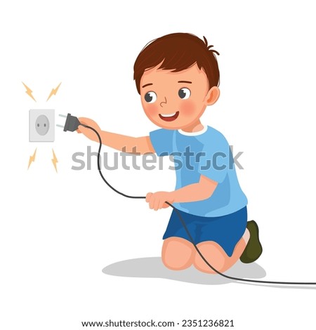 Cute little boy play with electricity put a plug into socket