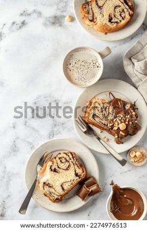 Foto Bild Drei Sauerteigbrötchen flachgelegt mit Mohn und Sesam auf einer Serviette auf einem Holzhocker