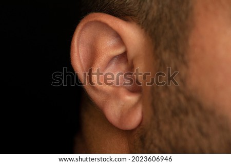 Close up shot of brown skinned man’s ear. Ear care , ear health, Hearing issues concept. selective focus