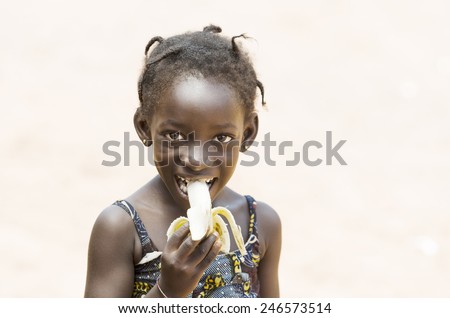 Health Symbol: Young African Girl Eating Healthy Banana Outdoors