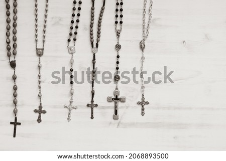 Similar – Image, Stock Photo A rosary hangs from an open Christian prayer book with the Our Father