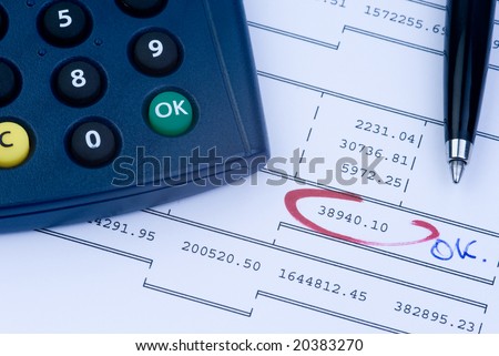 a calculator, a pen and a financial print-out