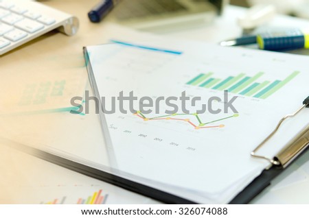 Financial paper charts and graphs on the table.
