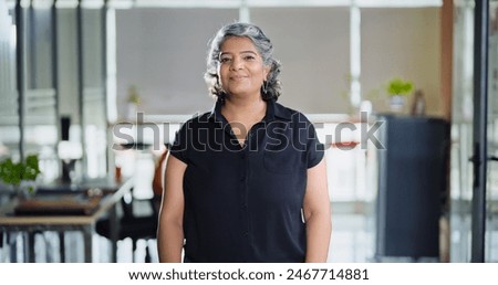 Similar – Image, Stock Photo An older woman is sitting on the sofa with a book. She is typing on her phone while smiling. She is protecting herself and staying home. Pandemic concept.