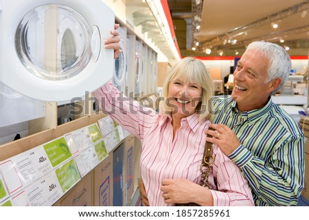 Senior couple in the electronics store shopping for a new washing machine