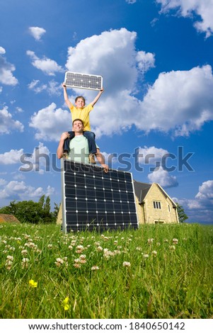 A boy sitting on the shoulders of a man and holding solar panel in his hands.