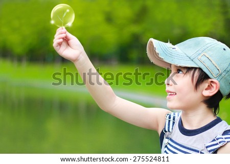 Little asian boy discovers the joy of grass in hands