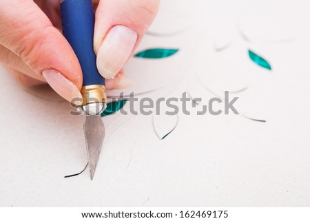 women\'s hand cutting flower from paper