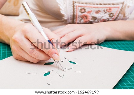 women\'s hand cutting flower from paper