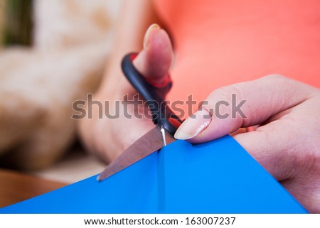 Woman\'s hand cutting paper