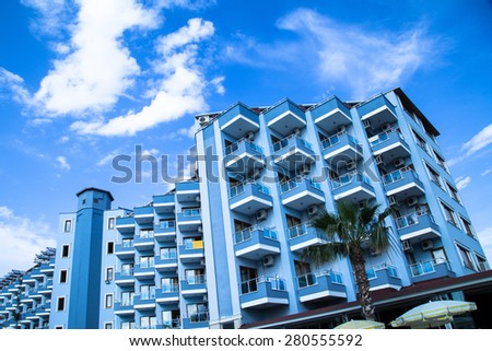 Frontal shot of big hotel building with palm